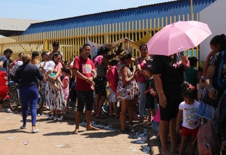 Sob forte calor, pessoas ficaram do lado de fora das escolas estaduais na espera por brinquedos para as crianças (Foto: Nilzete Franco/FolhaBV)