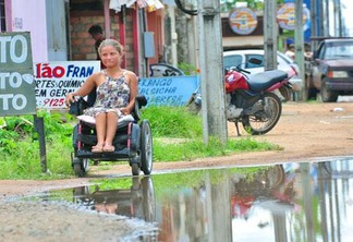Cadeirante Dyme da Silva precisa se arriscar em meio à lama e o trânsito intenso da rua (Foto: Rodrigo Sales)