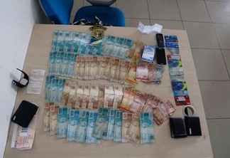 Com os três suspeitos foram encontrada grande quantia em dinheiro, cartões de saque bancário e uma folha de cheque (Foto: Wenderson de Jesus)