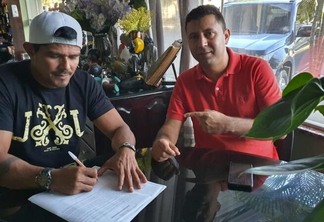 O jogador assinou contrato com o Timbú, ao lado do gestor do clube, Marcelo Pereira (Foto: Yago Dias/Náutico)