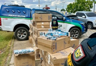 A proprietária do supermercado e as caixas de cigarro apreendidas foram encaminhadas à Polícia Federal. (Foto: reprodução/PMRR)
