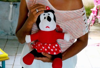 Mãe segurando o brinquedo favorito da filha (Foto: Wenderson Cabral/FolhaBV)