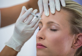 Close-up of female patient receiving a botox injection on forehead