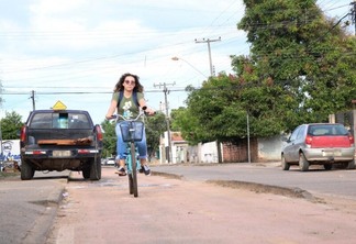 Ciclista pedala em ciclovia com carro estacionado (Foto: Nilzete Franco)