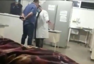 À esquerda, de azul, está o médico, e de jaleco branco, o enfermeiro; o nome dos envolvidos não foi divulgado (Foto: Reprodução)