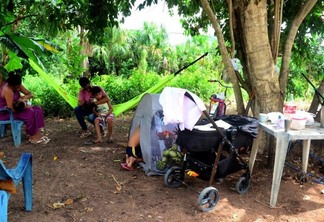 A família se abrigou embaixo da árvore, onde dormem em uma rede e uma barraca (Foto: Nilzete Franco/FolhaBV)