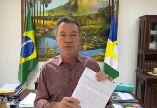 O governador Antonio Denarium exibe decreto que autoriza o reajuste (Foto: Reprodução)