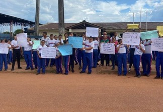 Pais, alunos e servidores da unidade de ensino se manifestaram em frente à escola com cartazes. (Foto: Divulgação)