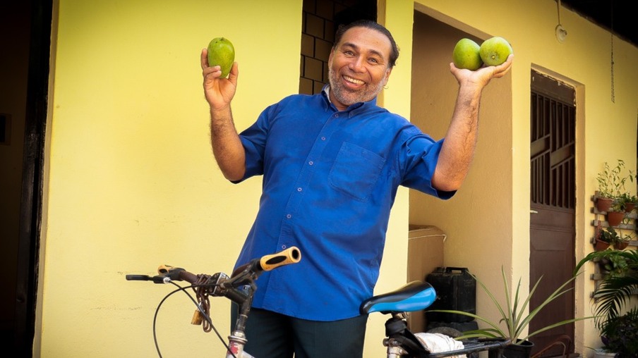 Antonio Paradas, 50 anos, vende os pacotes de manga verde pela cidade em uma bicicleta - Foto: Vanessa Fernandes/FolhaBV